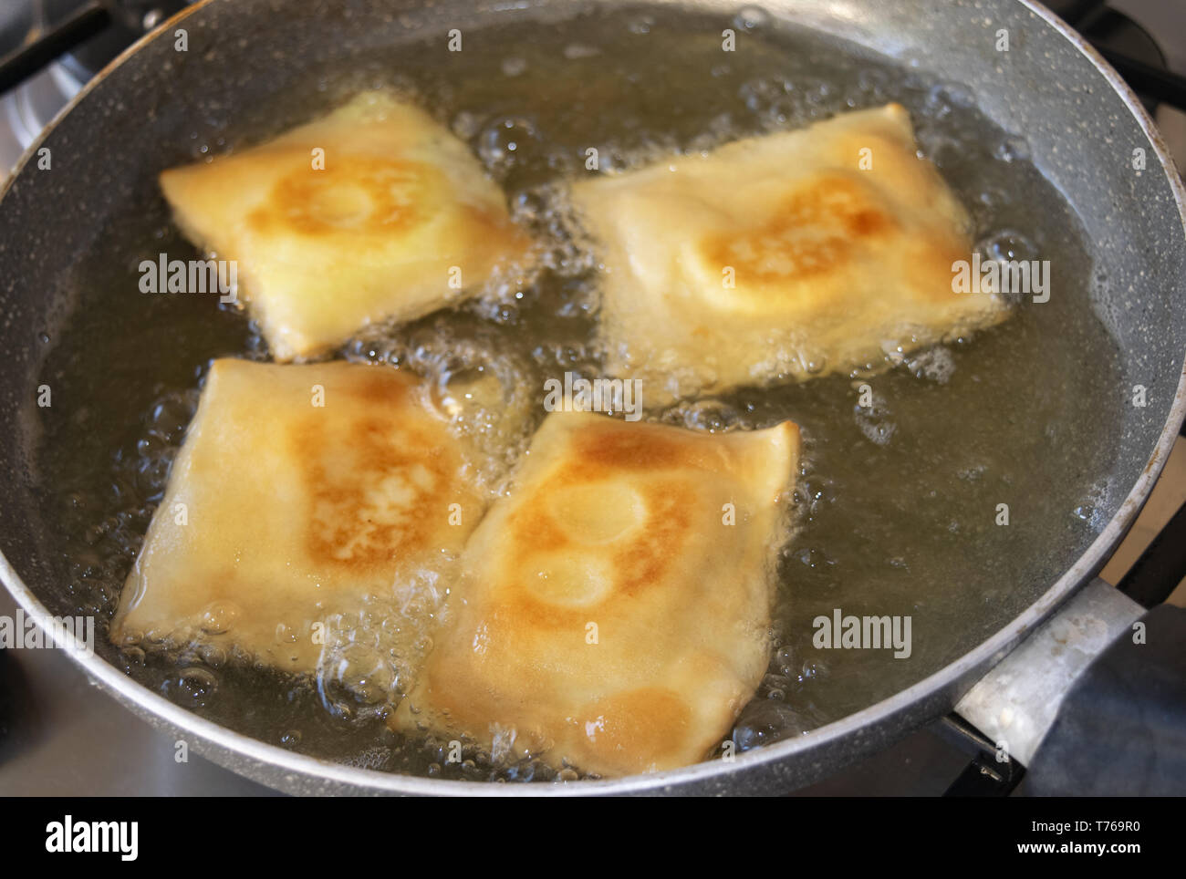 frying in boiling oil of sweet ravioli stuffed with ricotta Stock Photo