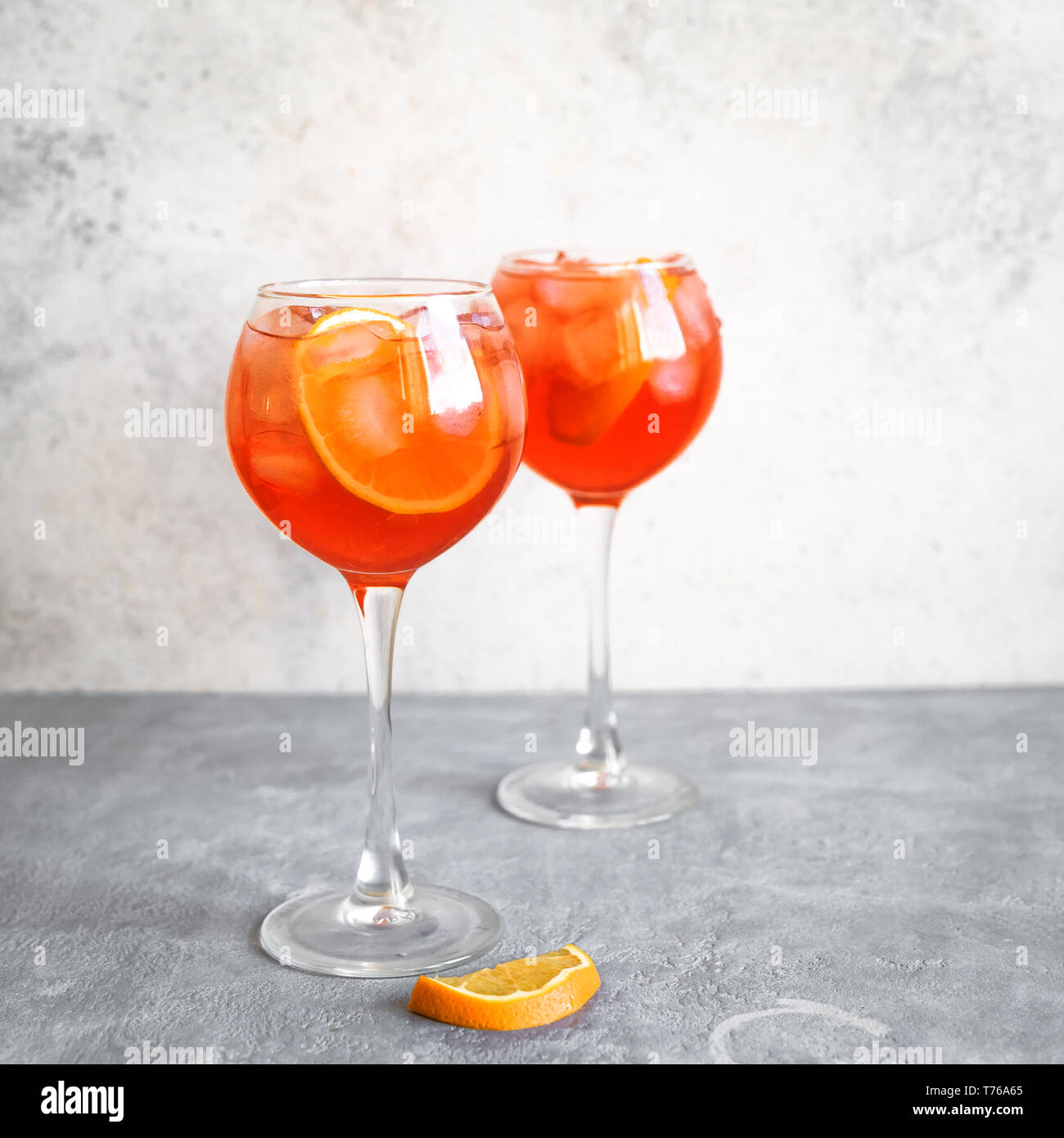 Aperol Spritz Cocktail in glasses on concrete table, copy space. Homemade cocktail with orange and ice. Stock Photo