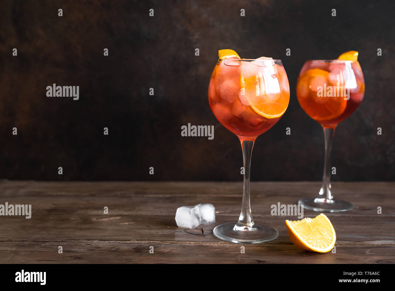 Aperol Spritz Cocktail in glasses on wooden table, copy space. Homemade cocktail with orange and ice. Stock Photo