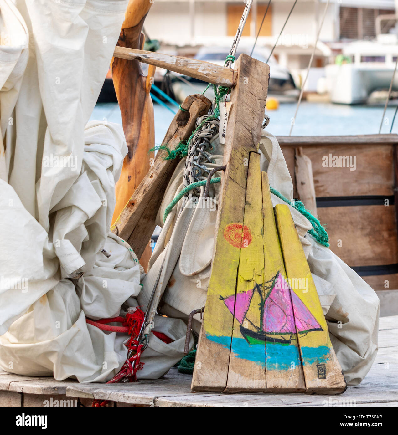 a colorful depiction of a sail boat painted on scrap wood in Gustavia, St Barts Stock Photo