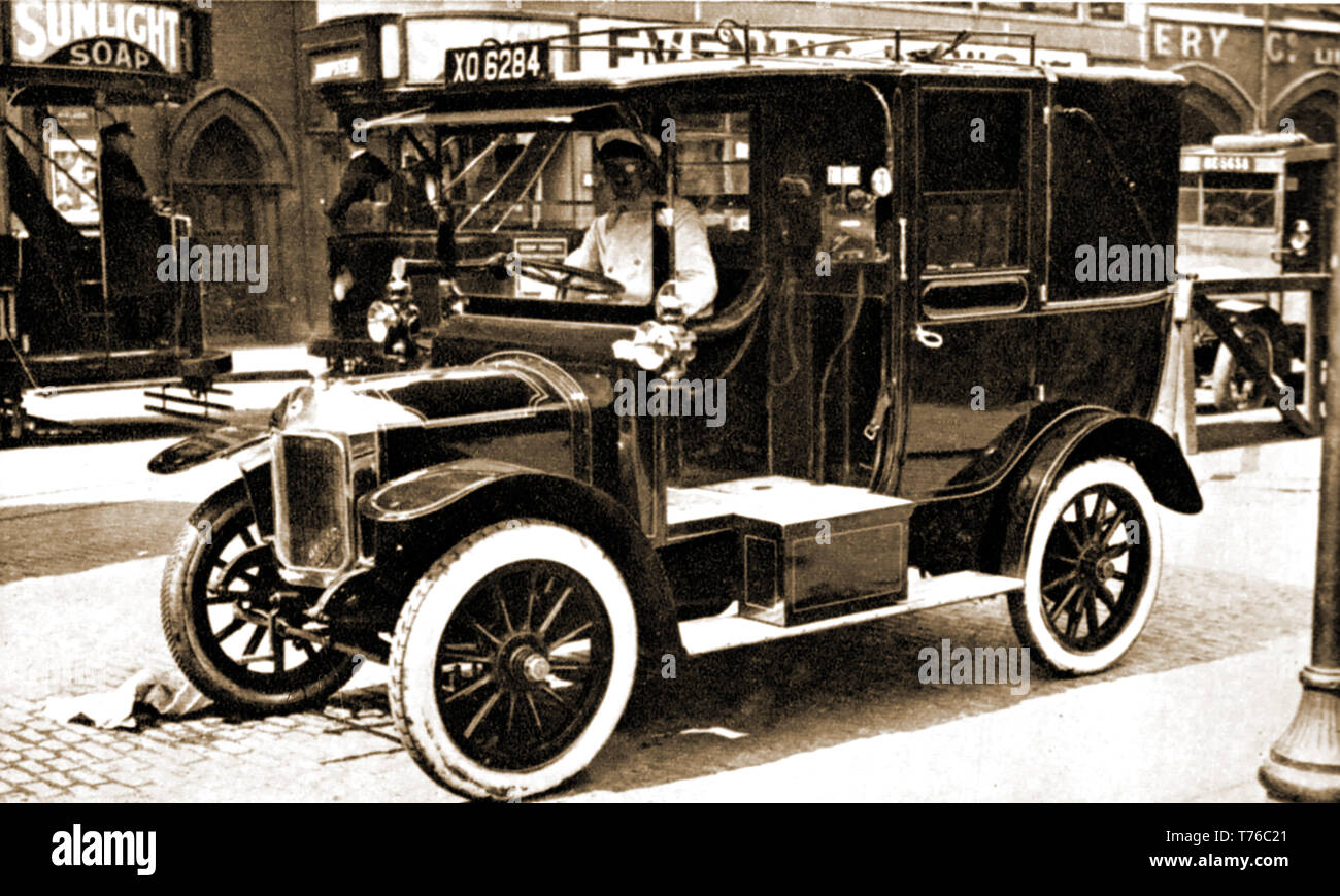Circa 1915  - An old  English taxi cab and its driver. Stock Photo