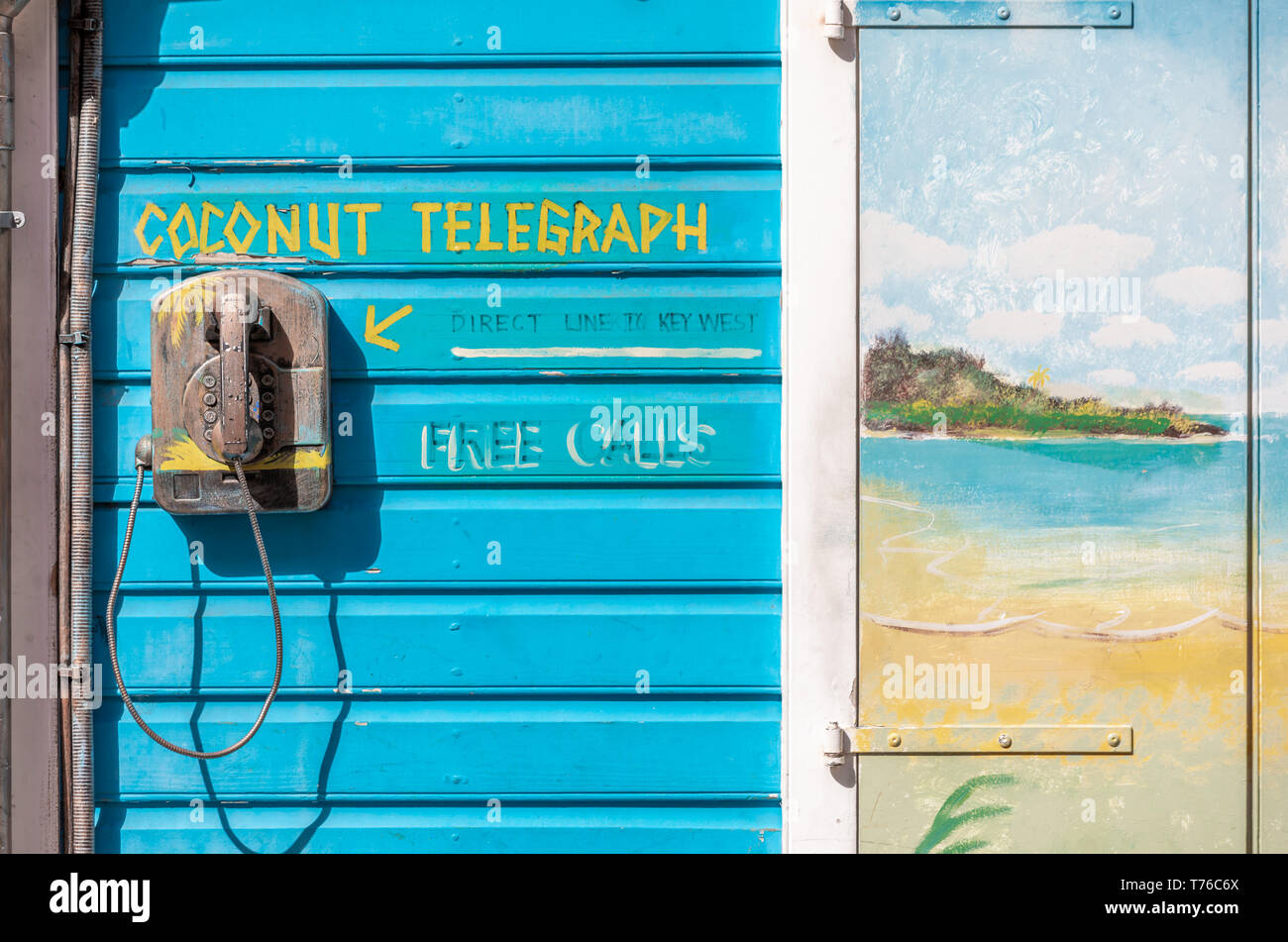 Coconut telegraph, an old phone mounted on an exterior wall in St Barts, explaining that it is a way to communicate directly with Key West Stock Photo