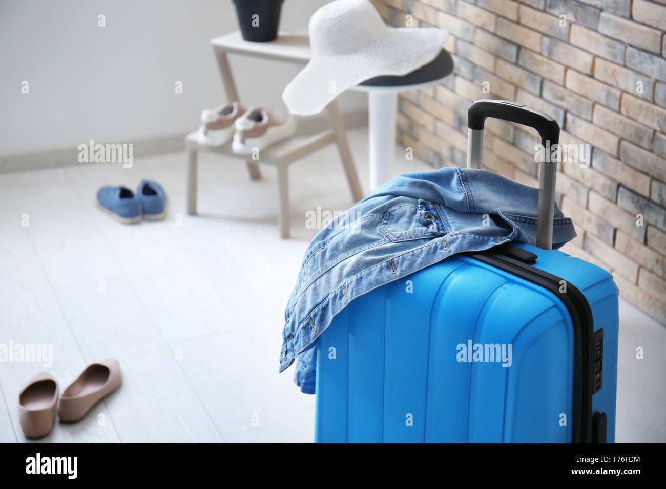 Packed suitcase and denim jacket in room Stock Photo Alamy