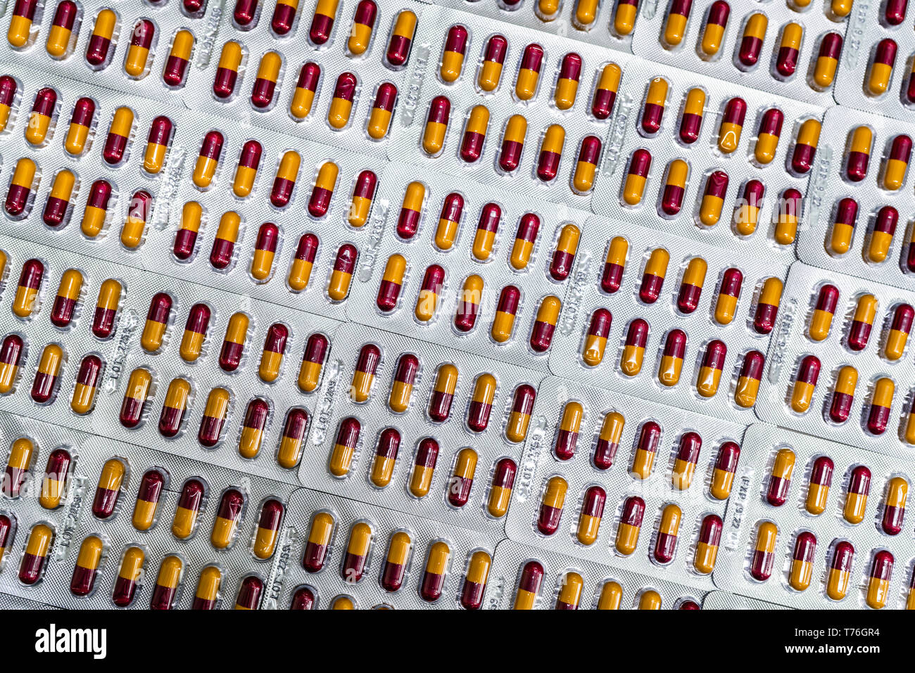 Pharmaceutical industry. Red-yellow capsule pills in blister pack. Pharmaceutical packaging. Pharmacy product. Global healthcare. Drug use in hospital Stock Photo