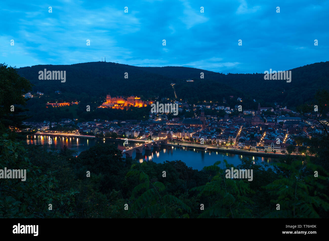 View on Heidelberg during dusk with wonderful details in city lights covering the famous illuminated castle and the old bridge across the river Neckar Stock Photo