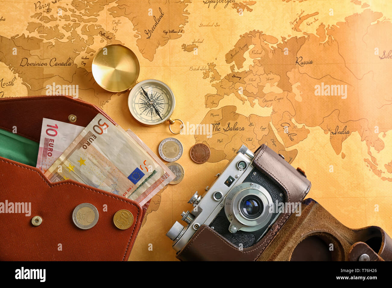 Photo camera compass and money - Photo Camera Compass And Money On Vintage World Map Travel Planning Concept T76H26 