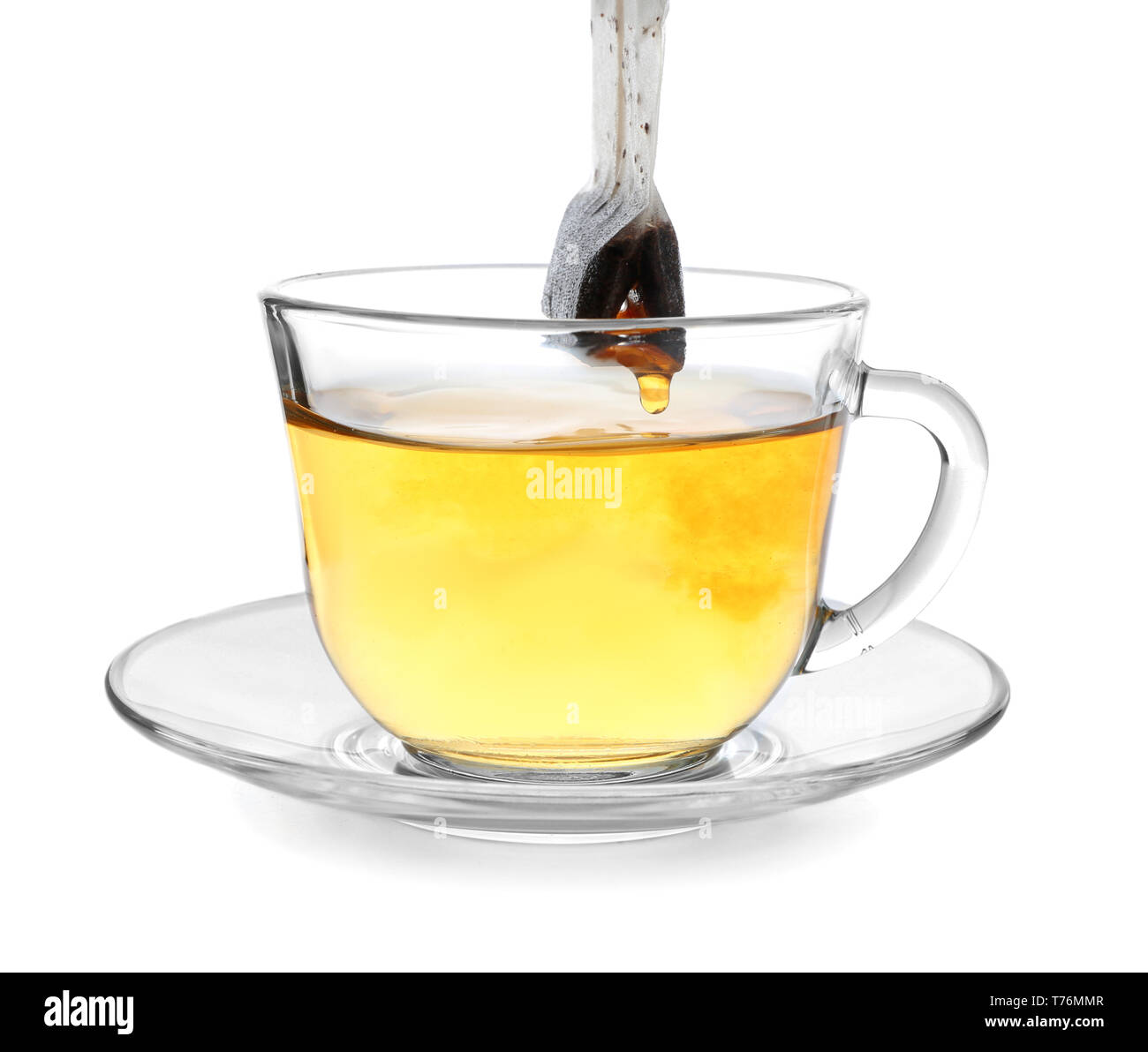 Brewing of hot beverage with tea bag in glass cup on white background