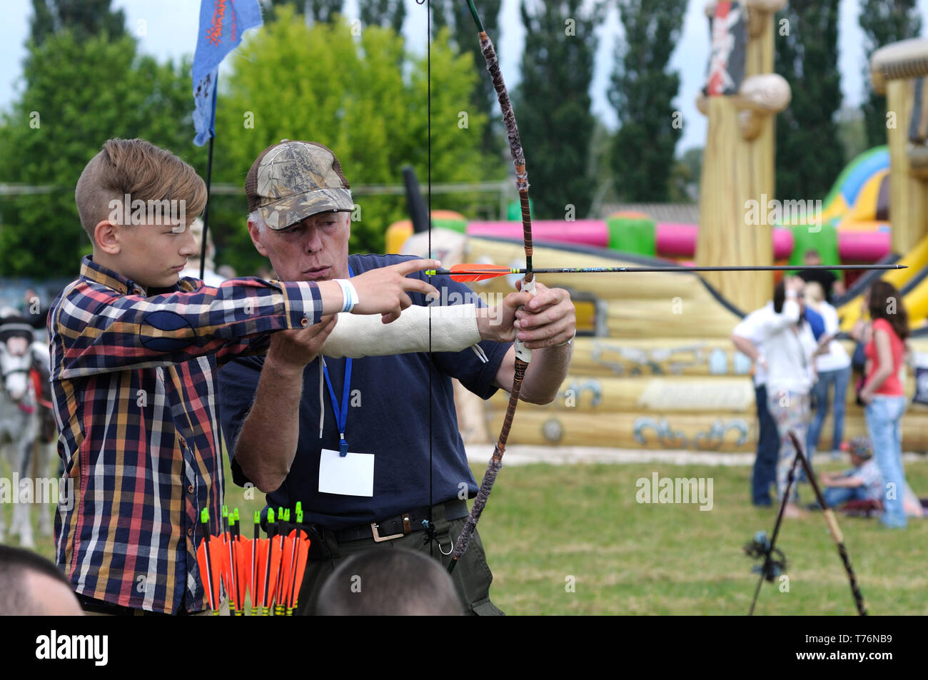 Archer teaching a boy archery. 7-th Air show. June 21,2018. Kiev, Ukraine Stock Photo