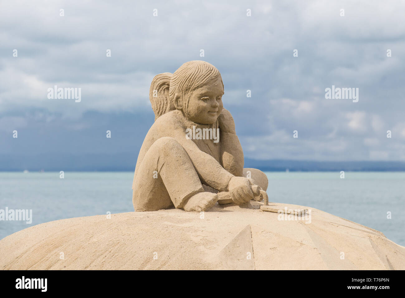 Sand sculpture with lake in the background Stock Photo