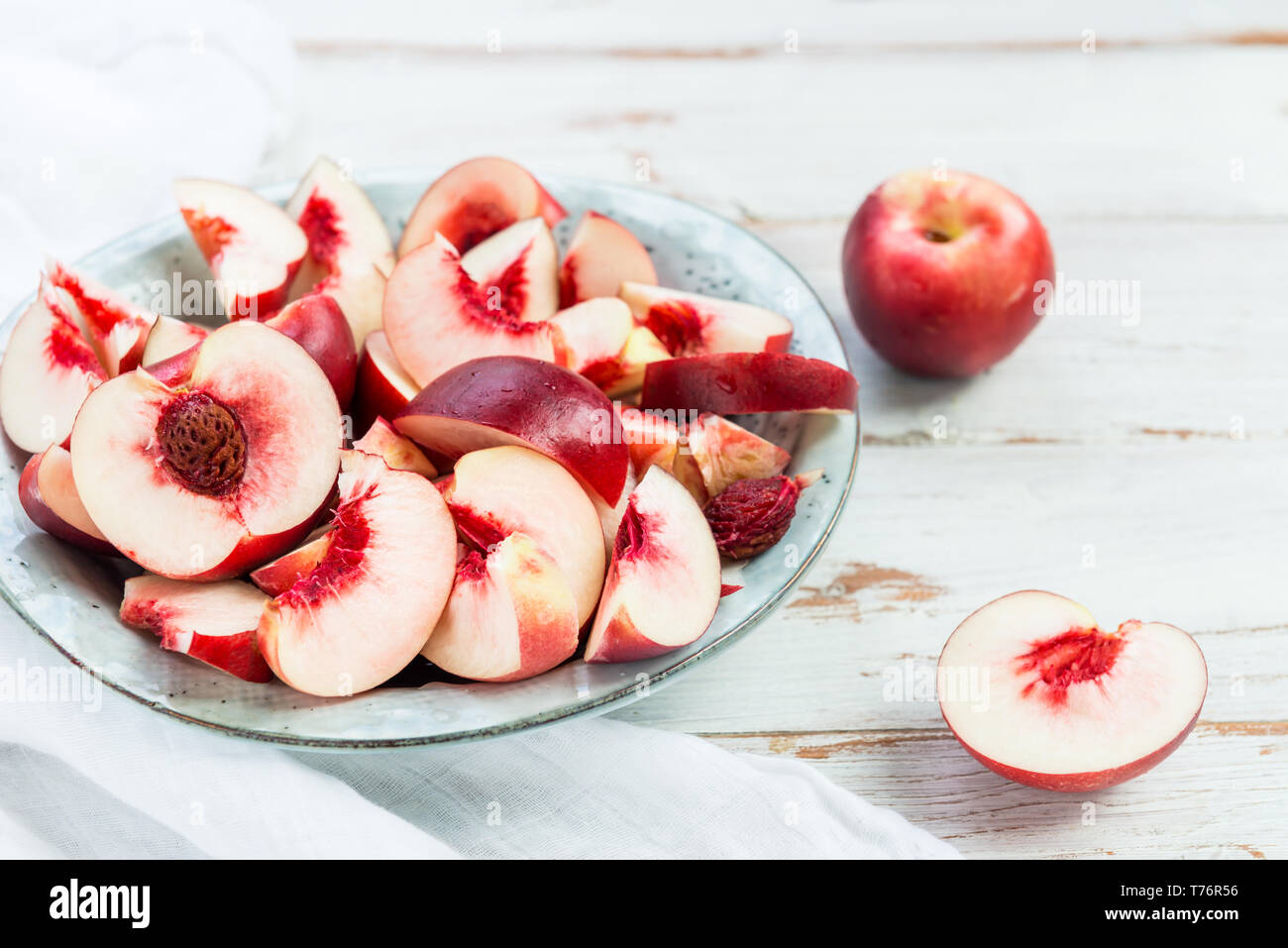 Fresh Nectarines Pieces in Rustic Ceramic Plate Stock Photo