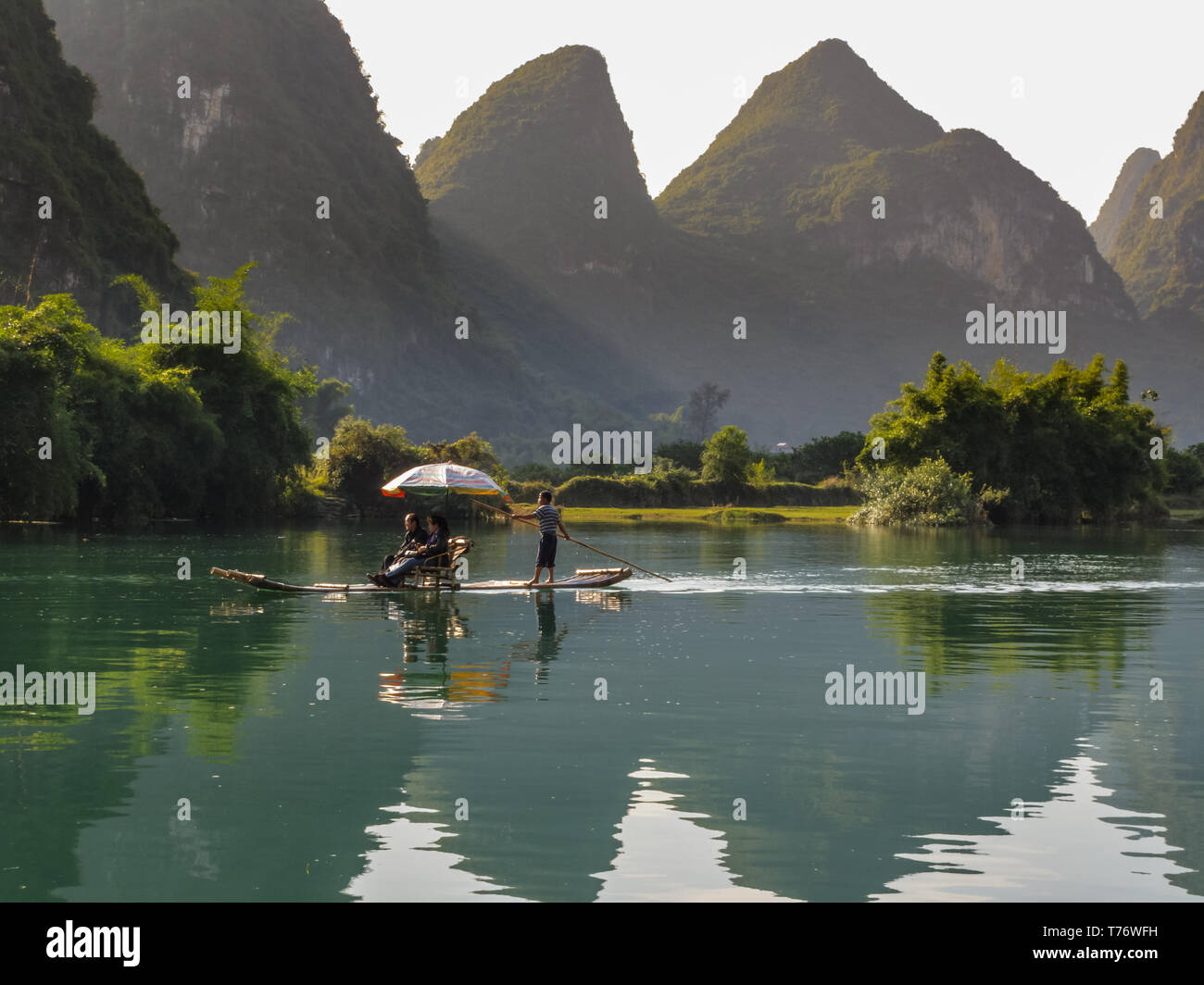 Tourists ride on raft paddled  down river to see the sights in Yangshao valley, China Stock Photo