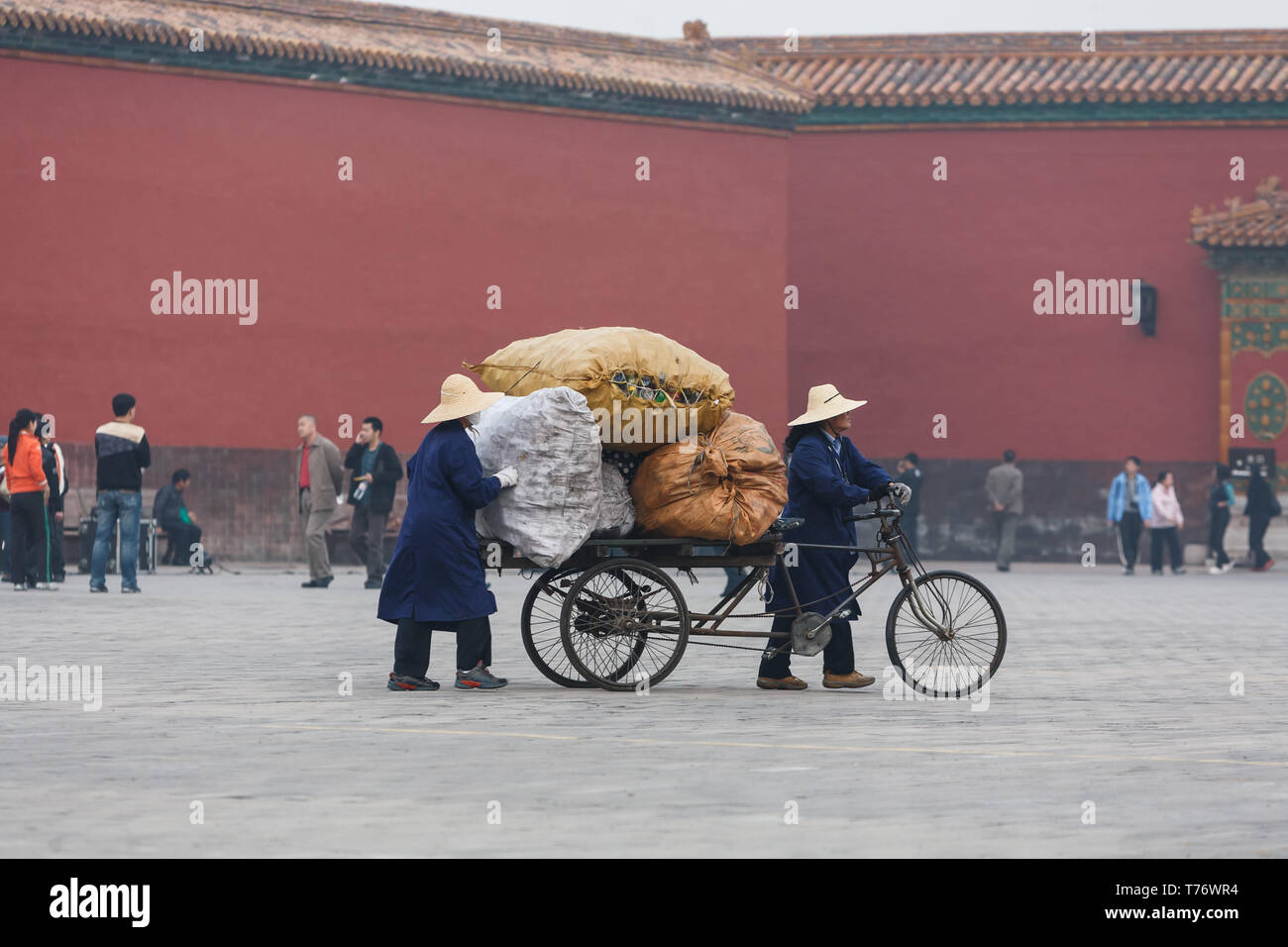 Trash collectors haul away huge bag of trash by bicycle in forbidden city, Beijing, China Stock