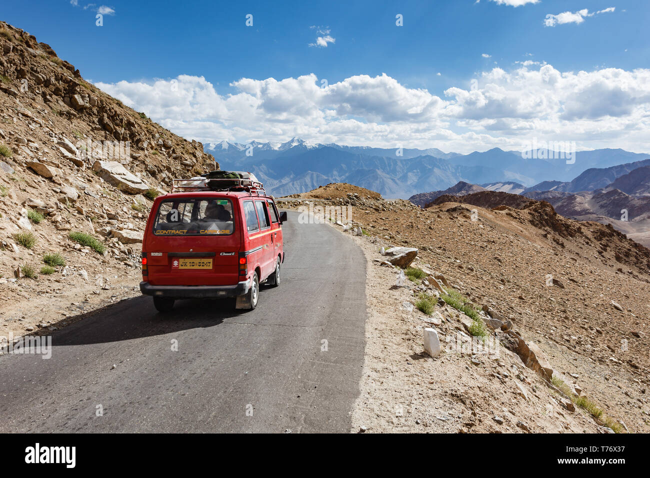 View of high mountain pass road  in Kashmir with support vehicle for bicycle tour riders crossing the mountains on bicycles Stock Photo