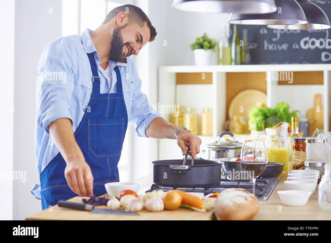 cooking, profession and people concept - male chef cook with smartphone at restaurant kitchen. Stock Photo
