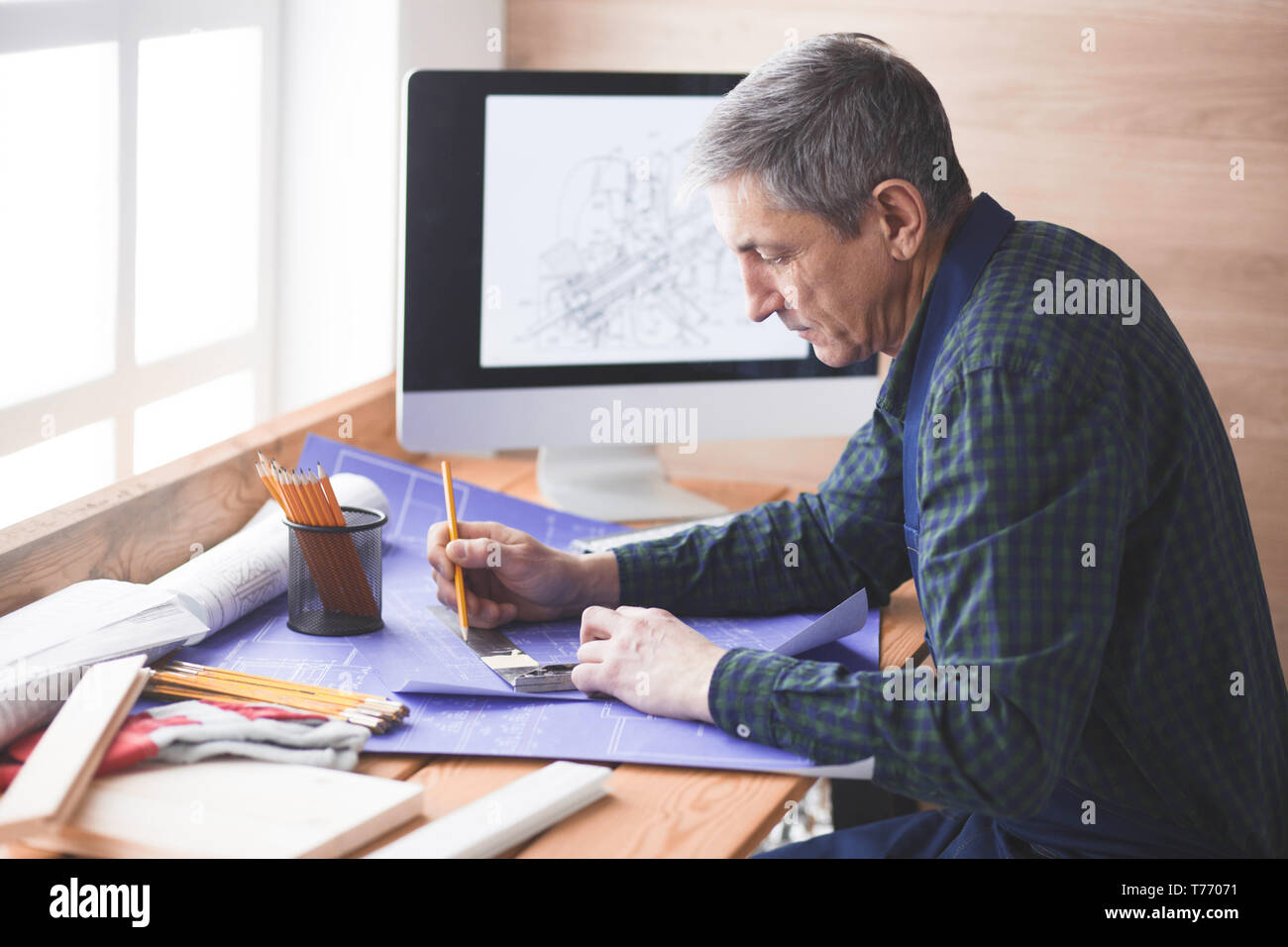 Engineer carpenter working on laptop and sketching project Stock Photo ...