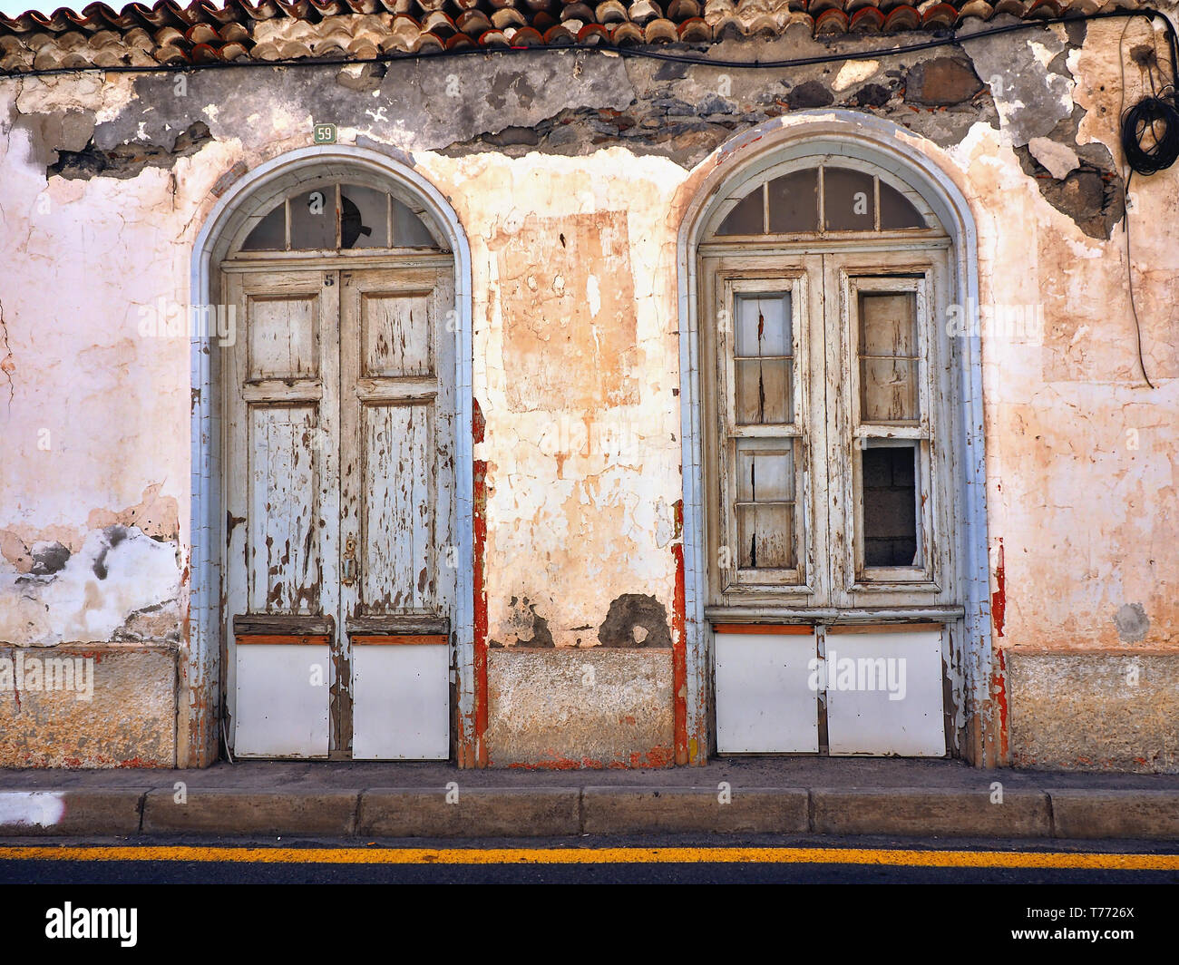 Front view of an old, dilapidated and rundown old town house in 'San Sebastian' on 'La Gomera' (Canary Island). crumbling plaster Stock Photo