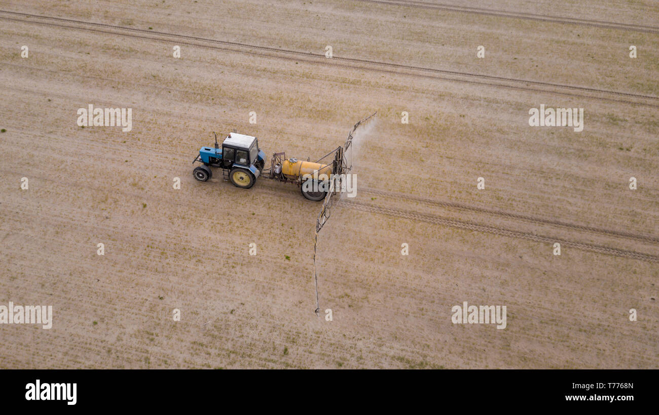 Aerial view of farming tractor plowing and spraying on field Stock ...