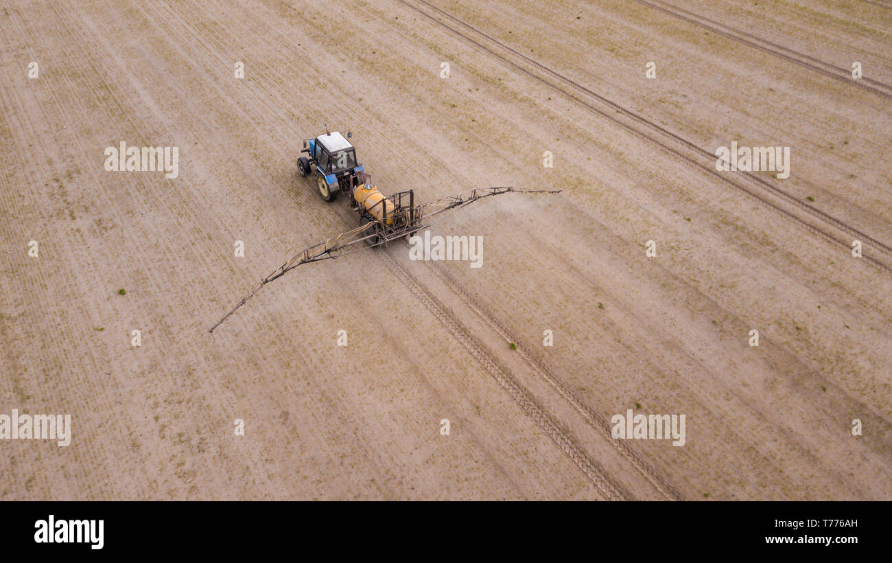 Aerial view of farming tractor plowing and spraying on field Stock ...