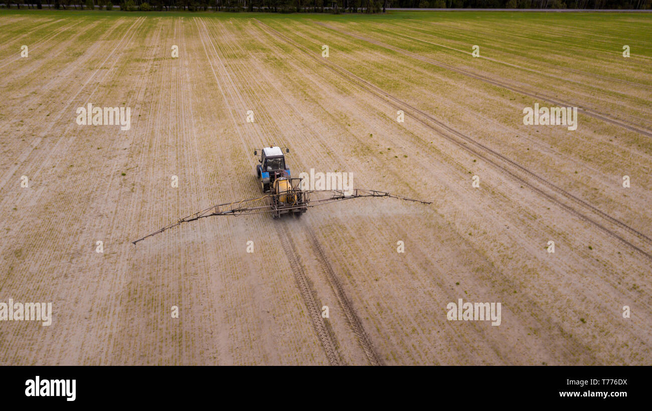Aerial view of farming tractor plowing and spraying on field Stock ...