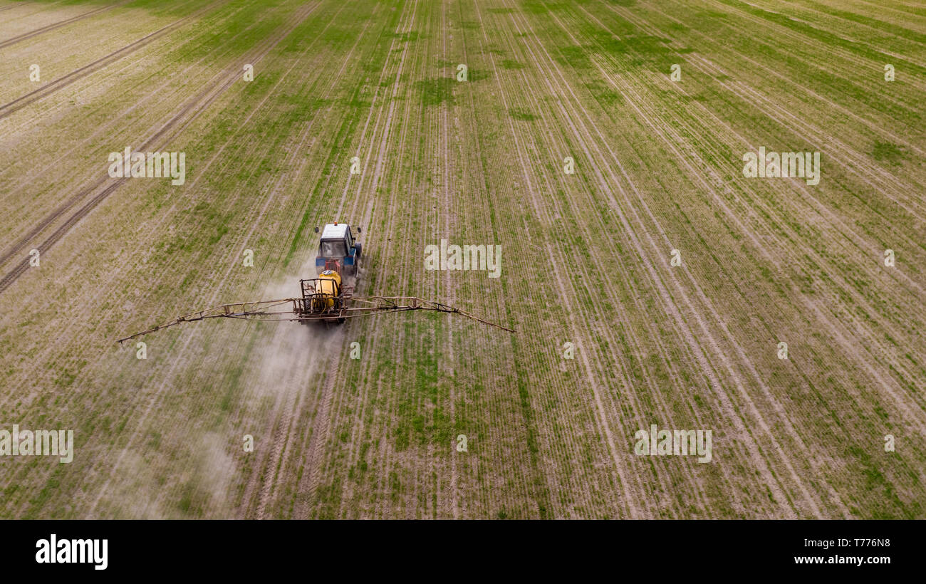 Aerial view of farming tractor plowing and spraying on field Stock ...