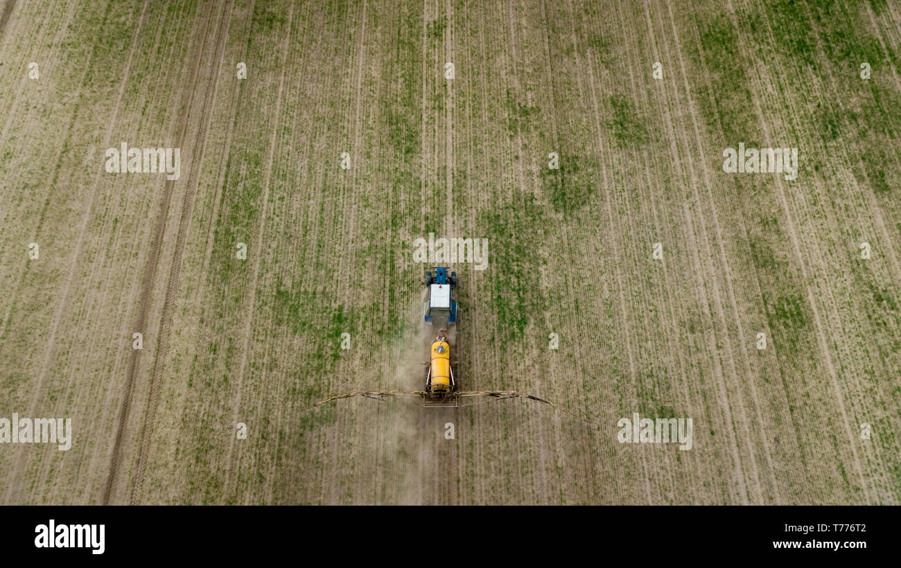 Aerial view of farming tractor plowing and spraying on field Stock ...
