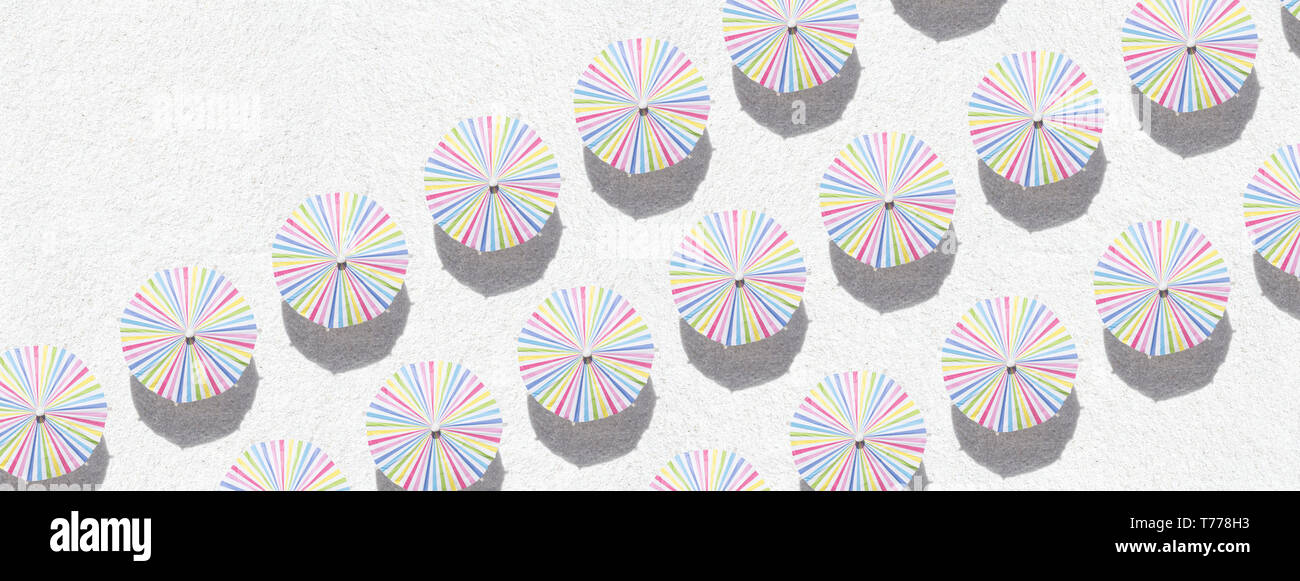 Colorful umbrellas on white sand - top view Stock Photo