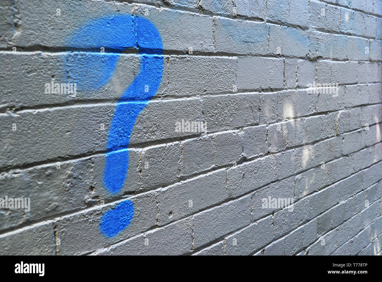Question mark on white brick wall Stock Photo