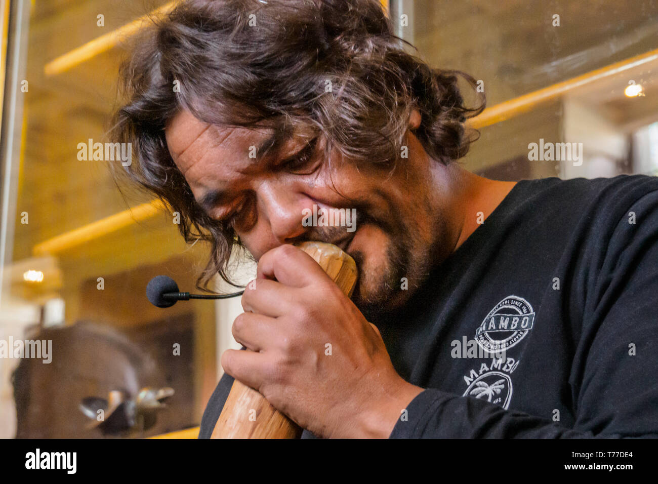 London, UK. 4th May 2019. Indigenous Australian campaigner Rodney Kelly starts his talk by playing a didgeridoo in front of the Gweagal shield in the unofficial tour of the British Museum by campaigners 'BP or Not BP?'  Samir Eskanda spoke on objects from 'biblical' excavations in Palestine, Yasmin Younis on recent looting from Iraq and Petros Papadopoulos on the Parthenon marbles. Credit: Peter Marshall/Alamy Live News Stock Photo