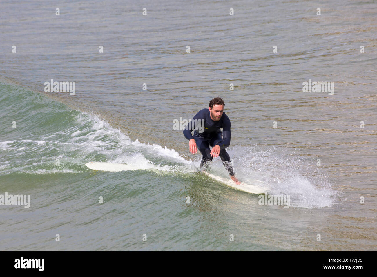 Bournemouth, Dorset, UK. 5th May 2019. UK weather: sunshine, but cool for the morning at Bournemouth beaches and mainly empty in stark contrast to the last Bank Holiday weekend.  Surfer in action.  Credit: Carolyn Jenkins/Alamy Live News Stock Photo