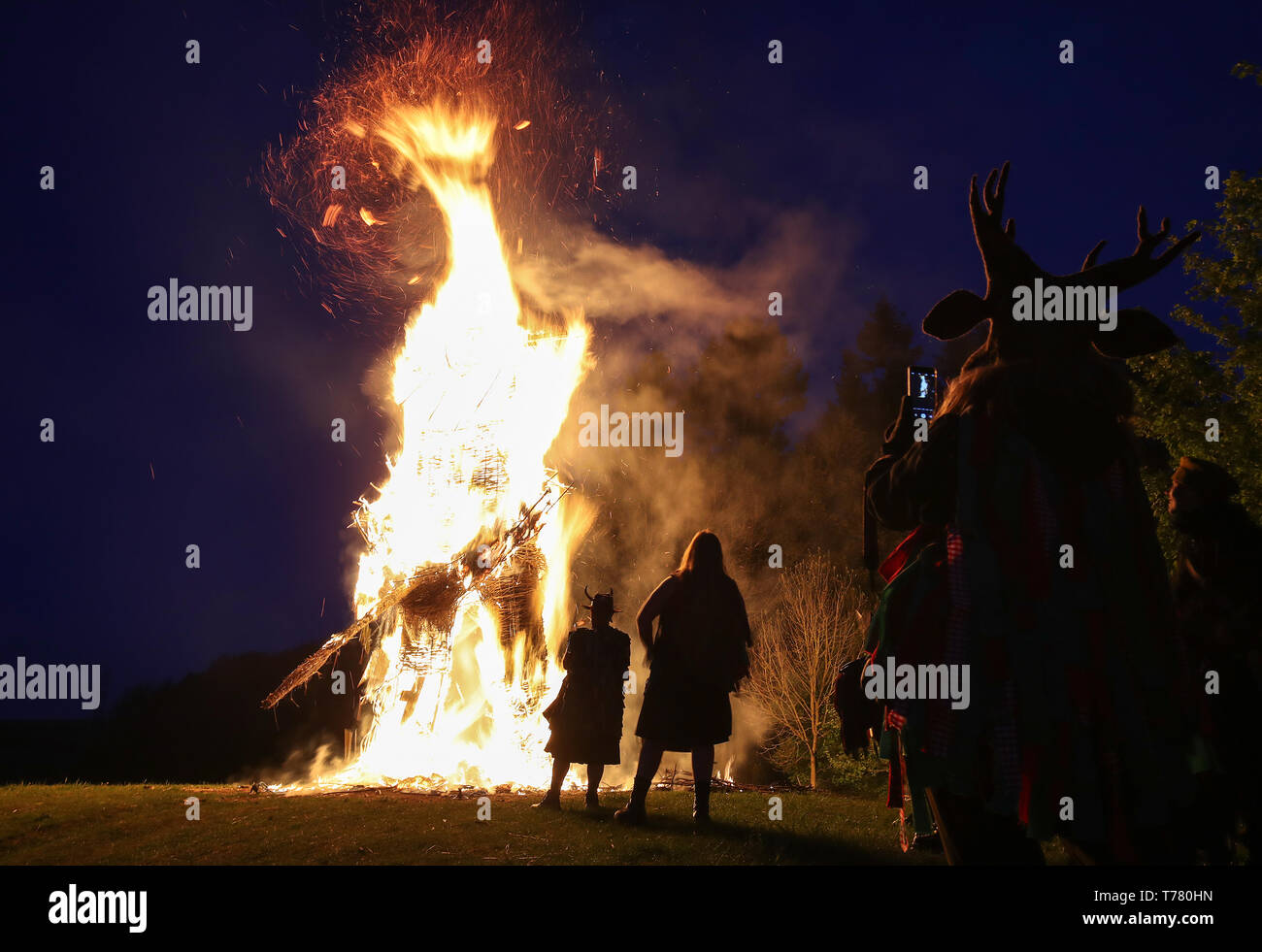Members of the Pentacle Drummers drum in front of the burning wickerman during the Beltain Festival, an ancient Celtic celebration to mark the beginning of summer, at Butser Ancient Farm, Waterlooville, Hampshire. Stock Photo