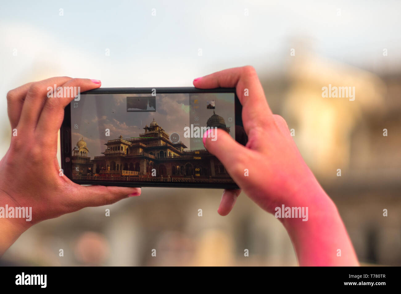 Tourist taking a photo of the famous albert hall in jaipur with a