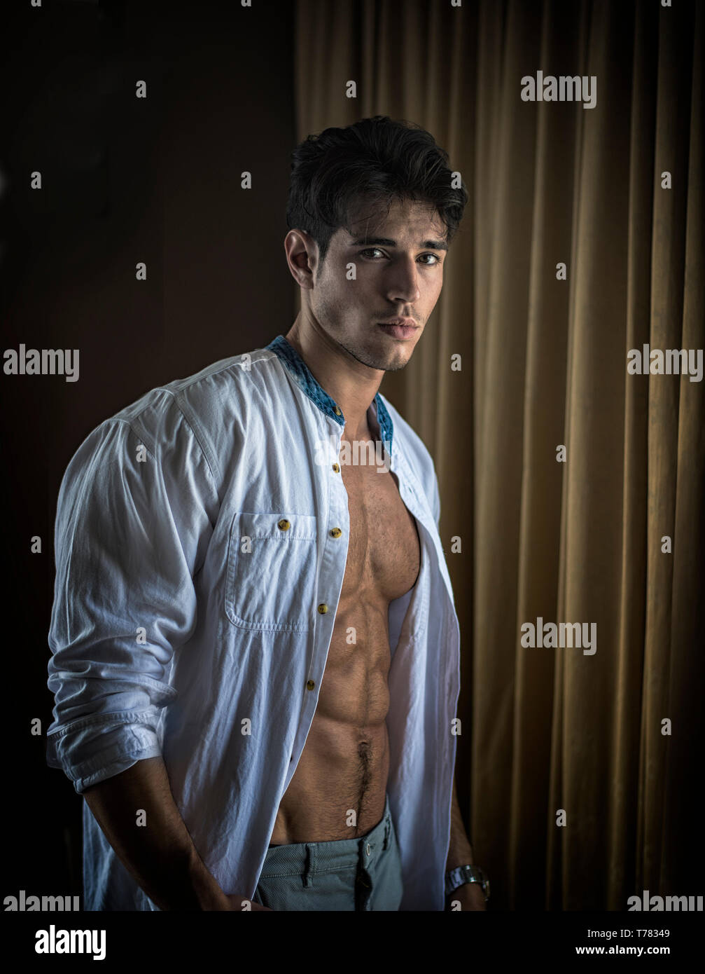 Sexy young man dressing by window curtains Stock Photo - Alamy