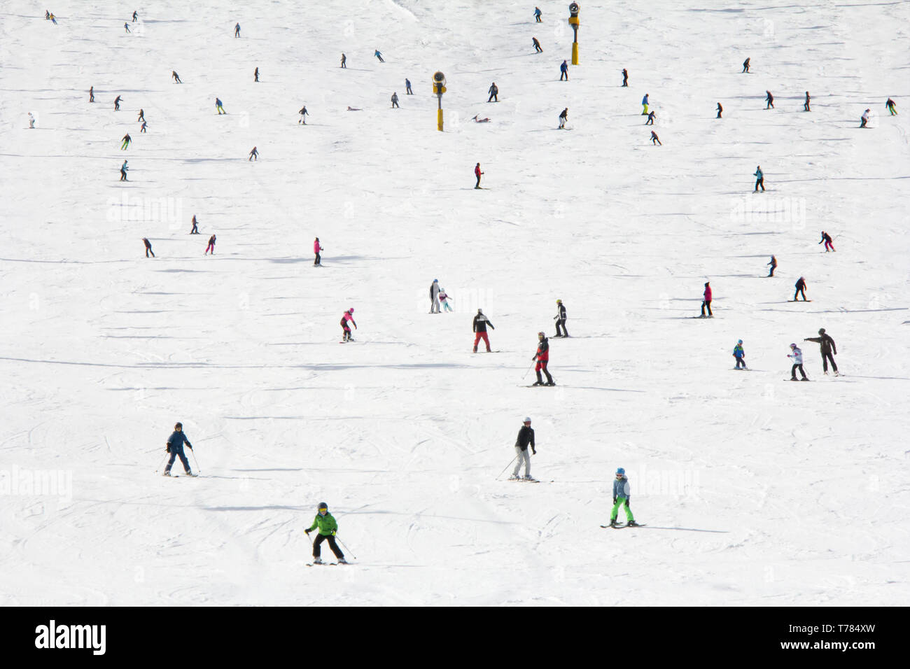Lots of skiers and snowboarders on the slope at ski resort Stock Photo