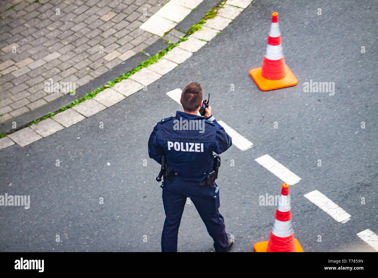ESSEN / GERMANY - APRIL 29 2019 : Police man communicating on walkie-talkie Stock Photo