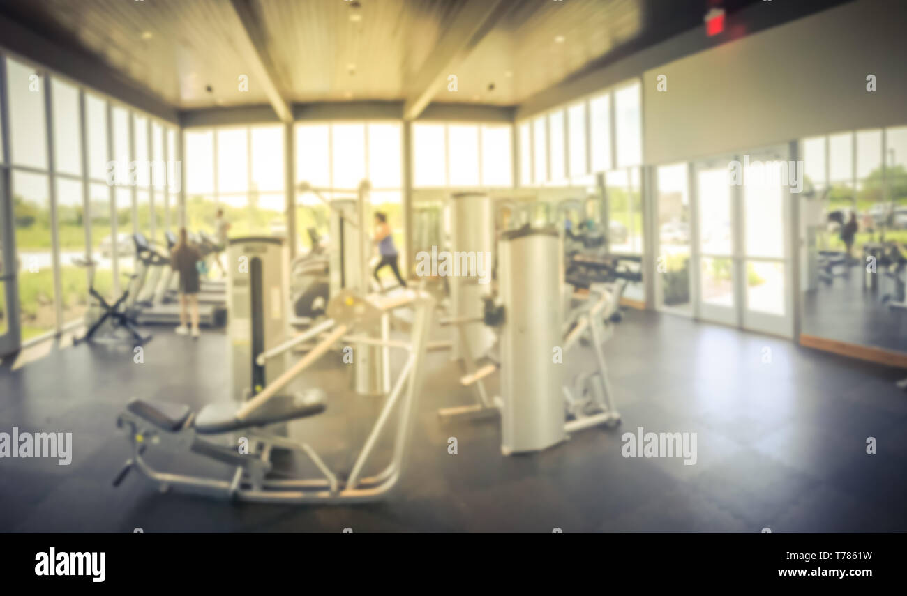 Panoramic blurry background open fitness center with people workout at