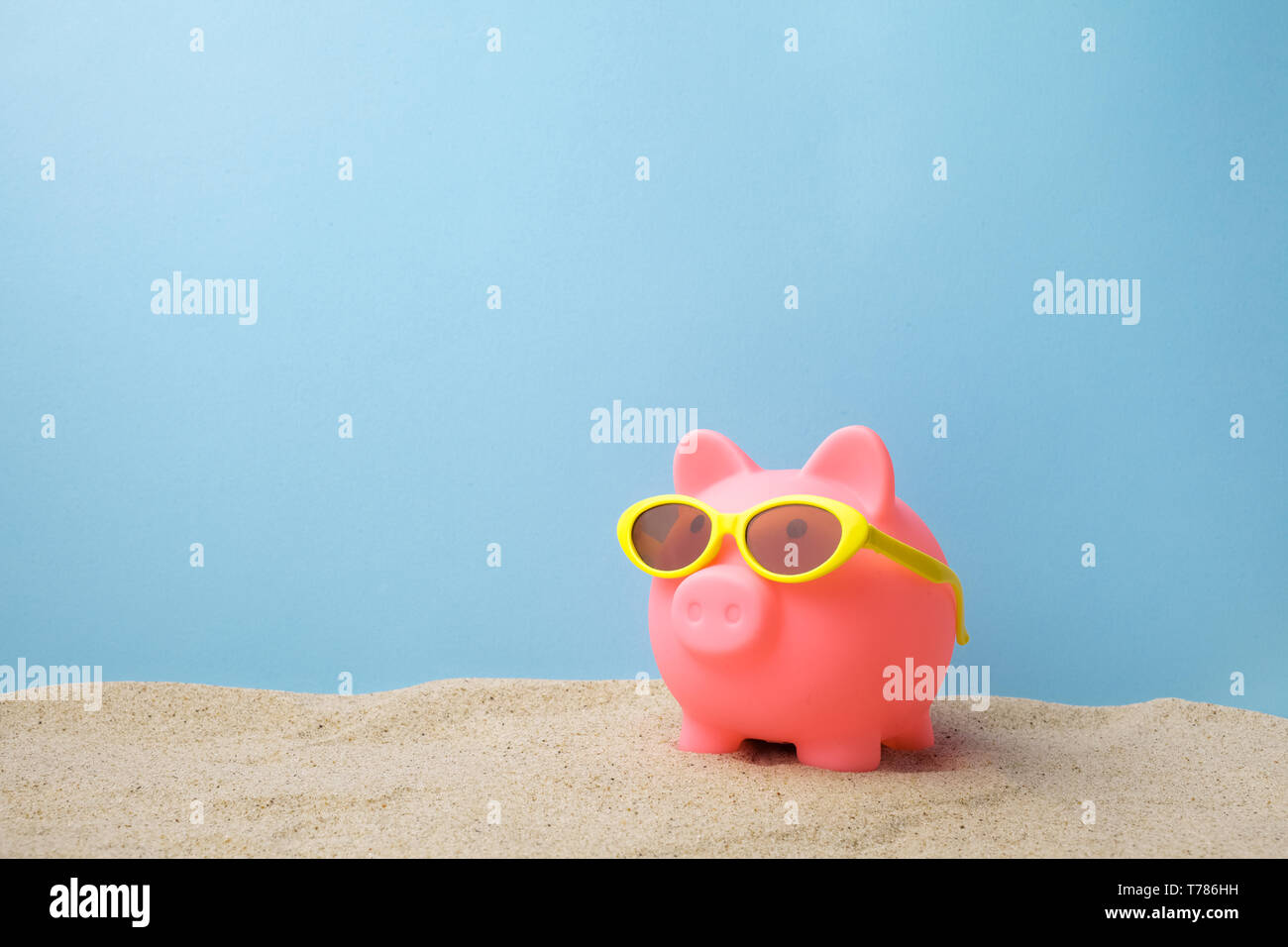 Piggy bank with sunglasses on the sand beach Stock Photo - Alamy