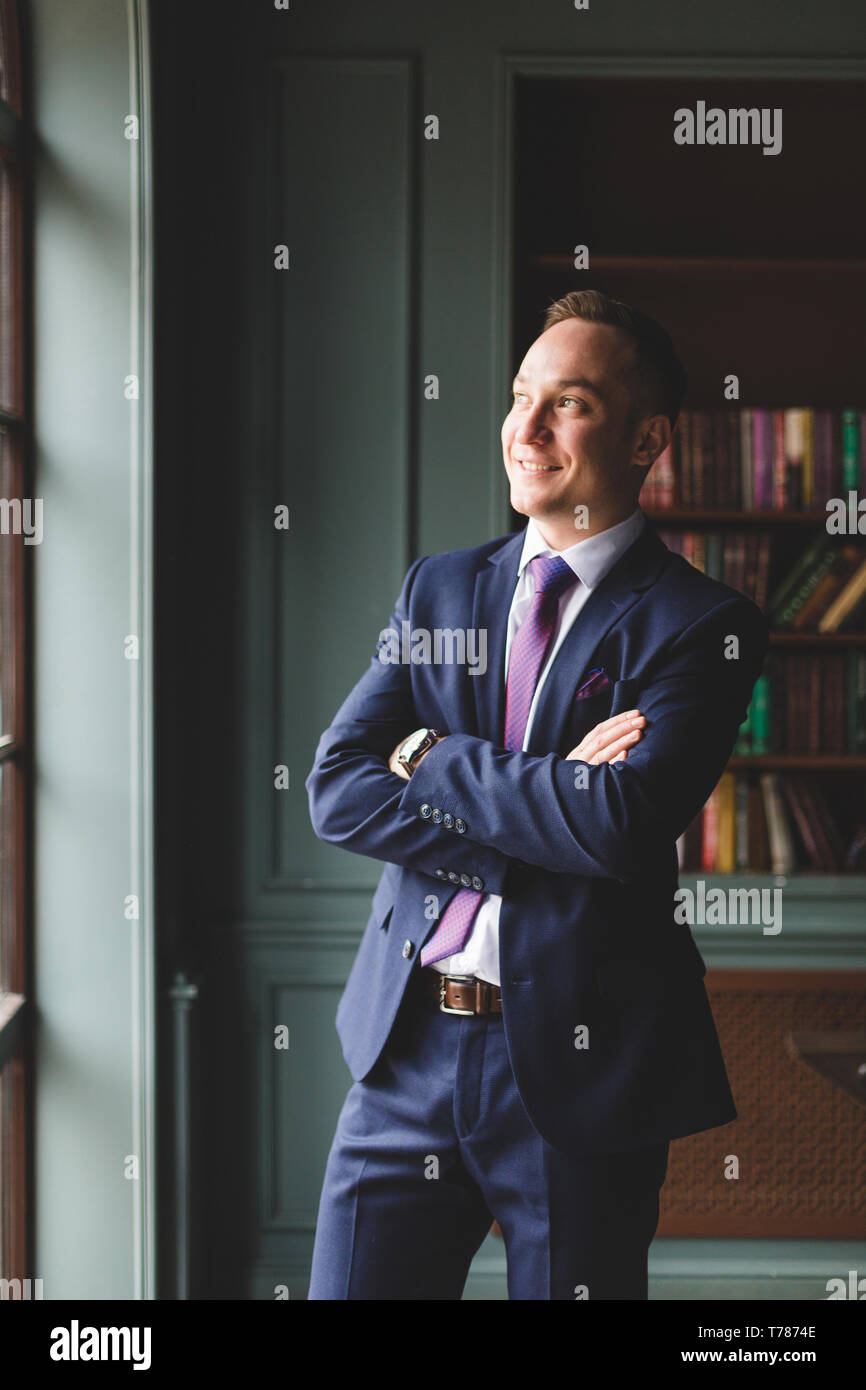 Portrait of a successful businessman standing with arms crossed on his ...