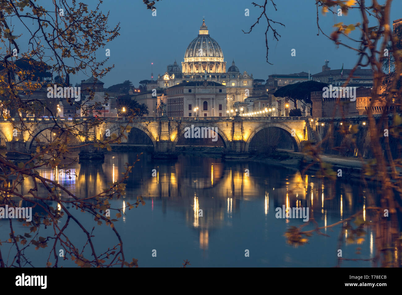 Aurelius Bridge or Ponte Sisto Bridge with St Peters Basilica and Tiber River at the blue hour with artificial lighting and reflections. Stone bridge Stock Photo