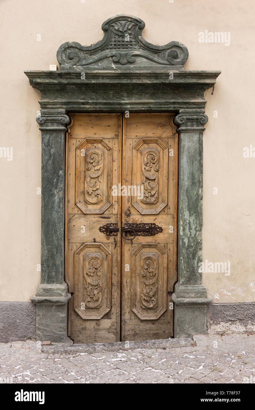 Bormio: porta in legno di antica casa con stipite in pietra.  [ENG]  Bormio: old house wooden door with stone jamb. Stock Photo
