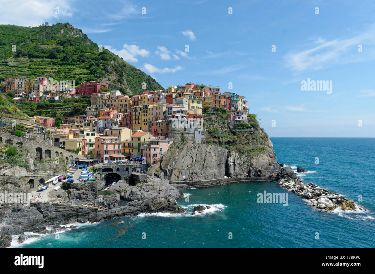 A scenic view the beautiful, vibrant buildings of Manarola in the Cinque Terre, Italy on a clear day under a bright blue sky Stock Photo