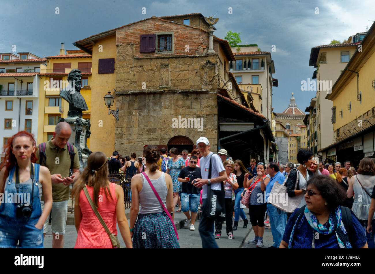 The crowd near the bust of Benvenuto Cellini on a busy Ponte Vecchio in Florence (Firenze), Italy Stock Photo