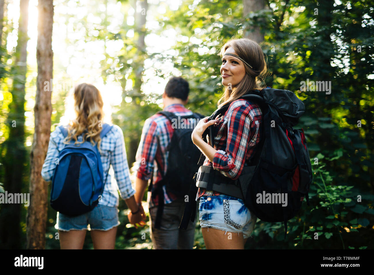 Beautiful woman and friends hiking in forest Stock Photo - Alamy