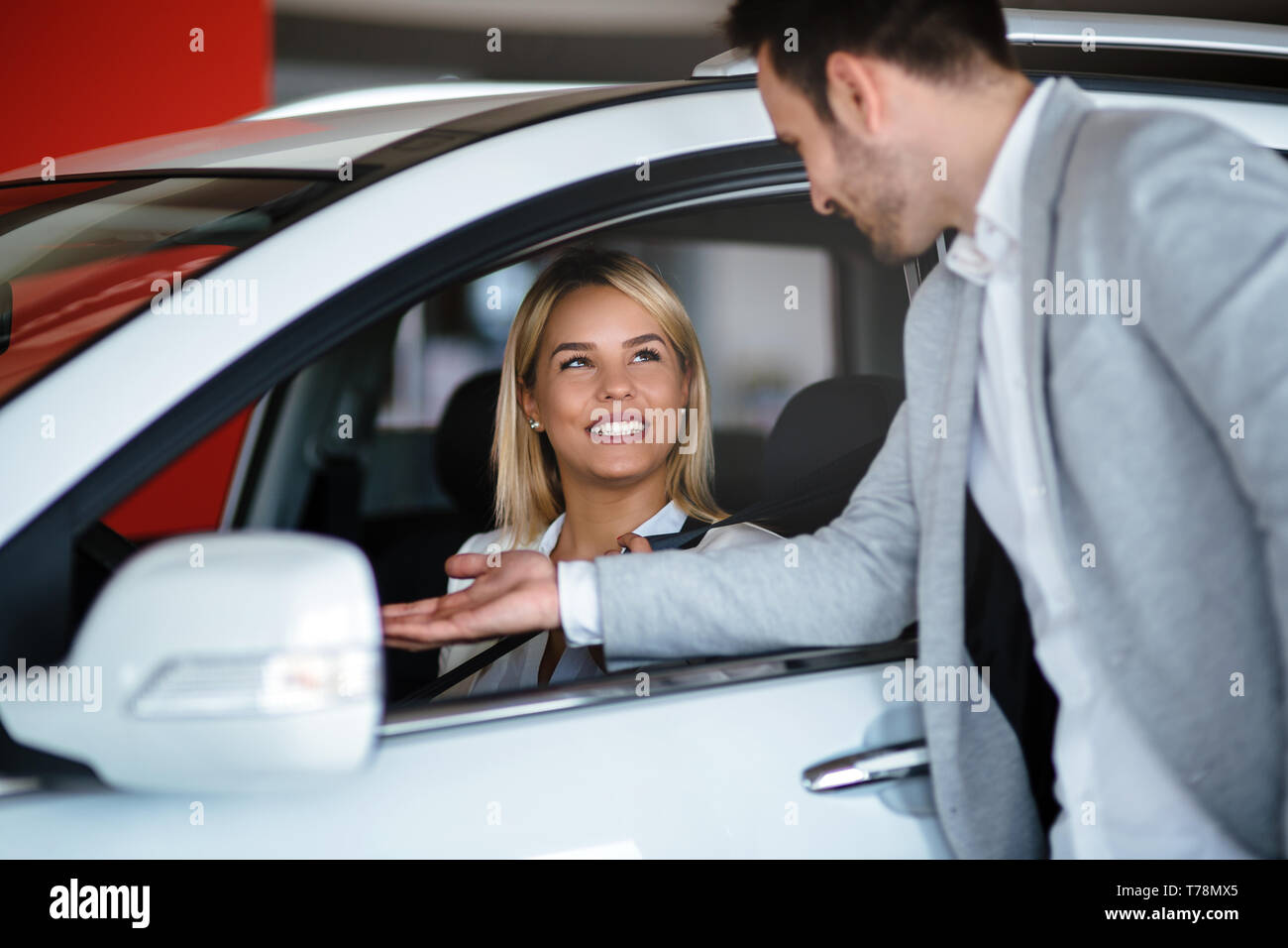 Woman buying a car in dealership sitting in her new auto Stock Photo