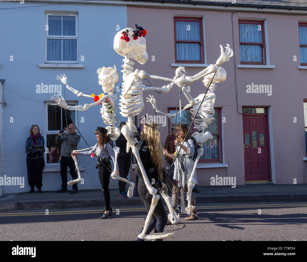 young women dancing as giant mannequin skeletons at a jazz festival Stock Photo
