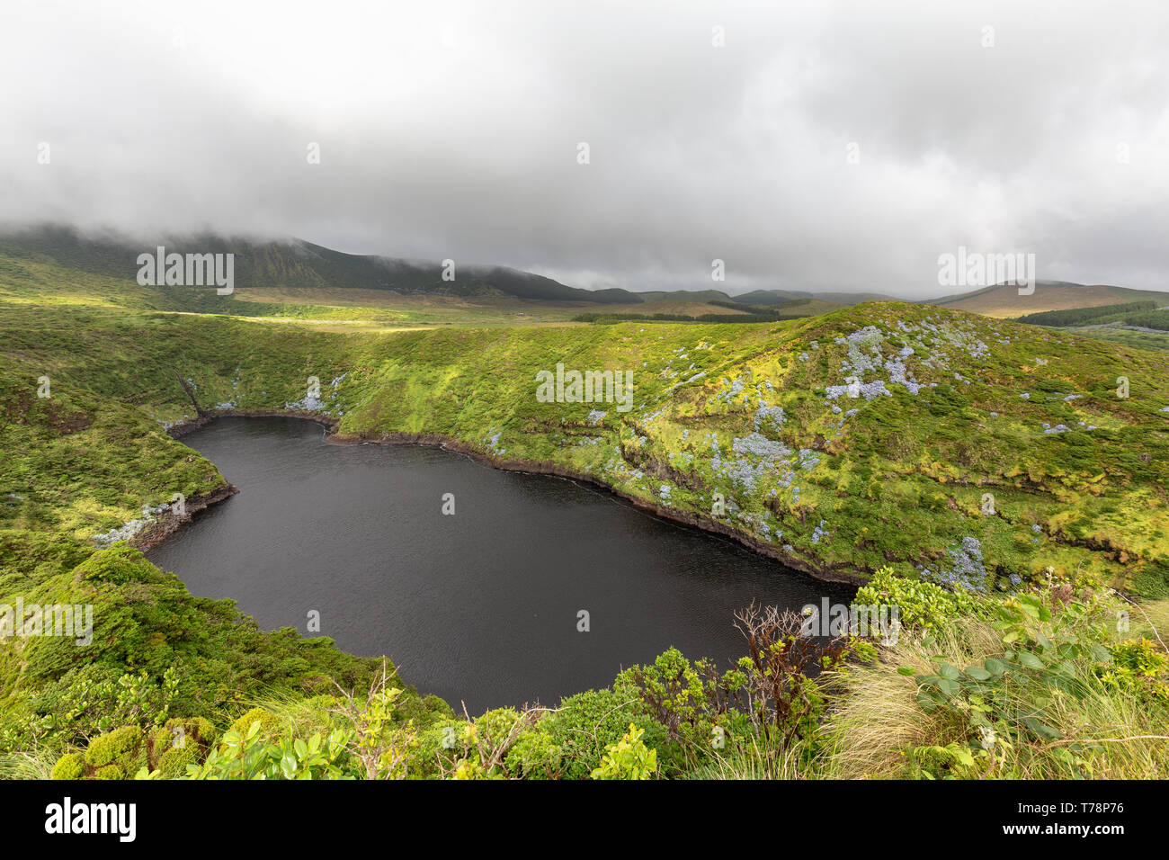 The dark crater lake, Lagoa Comprida on the island of Flores in the Azores. Stock Photo