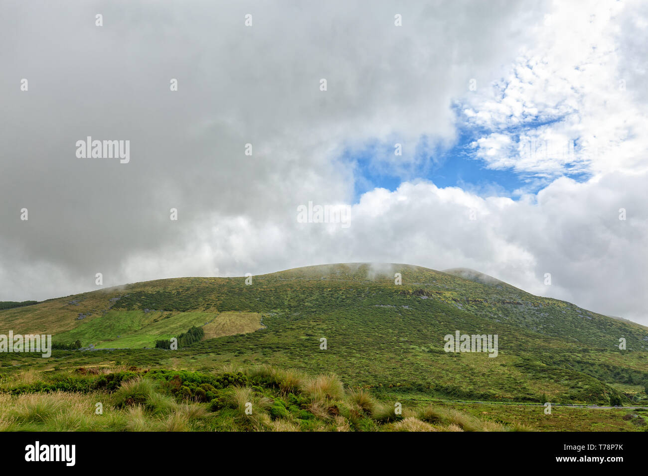Blue sky peaking out above a mountain on Flores island in the Azores. Stock Photo
