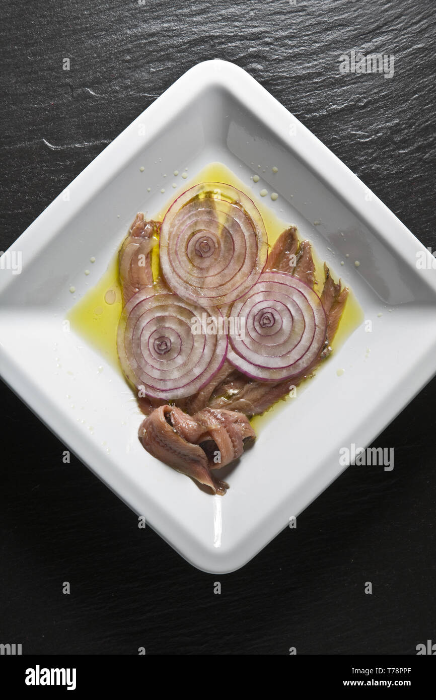 Un piatto con alici (acciughe) e cipolle. [ENG] A plate of anchovies and onions. Stock Photo