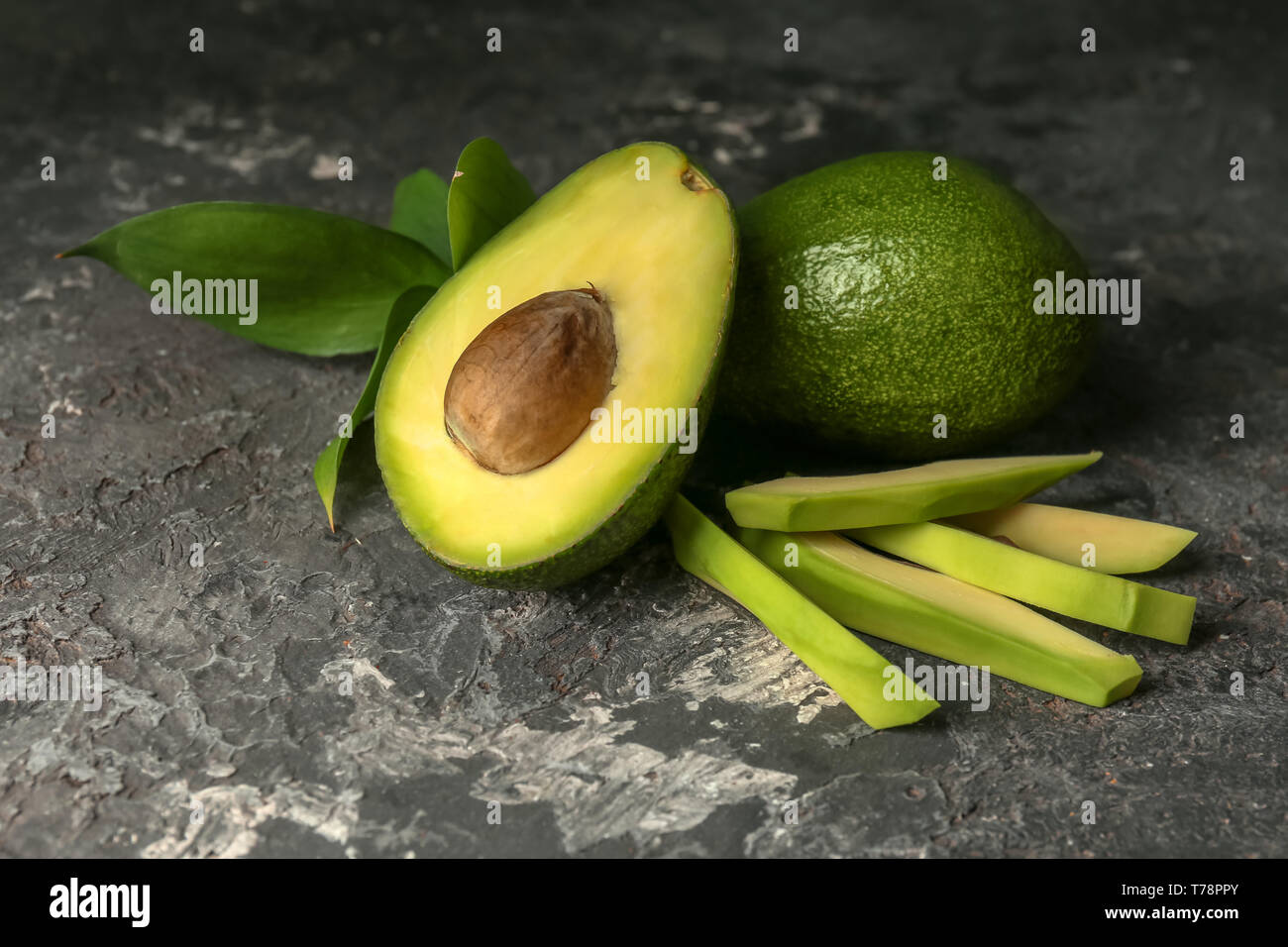 Cut avocado on grey table Stock Photo - Alamy