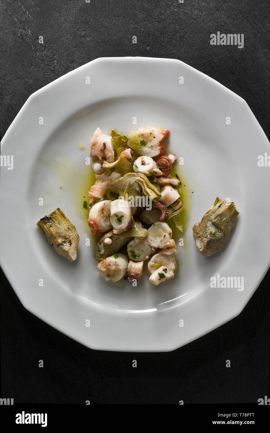 Un piatto di insalata di polpo con carciofi.  [ENG] A plate of octopus salad with artichokes. Stock Photo