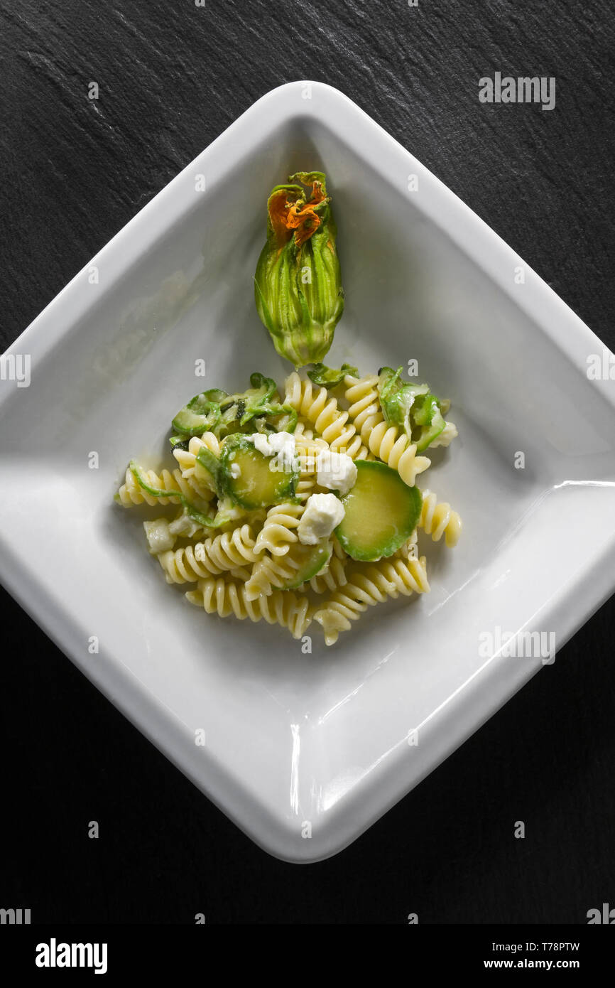 Un piati di fusilli con sugo di zucchine e mozzarella. [ENG]   A dish of rotini, with zucchini and mozzarella. Stock Photo